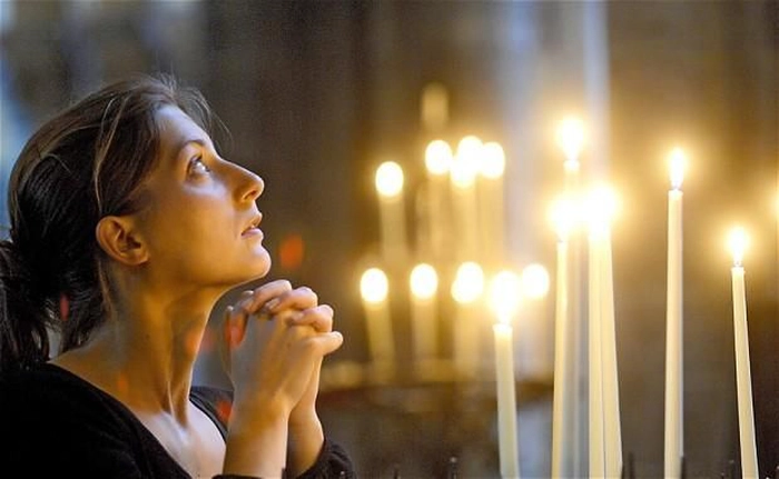 femeie care se roaga in biserica