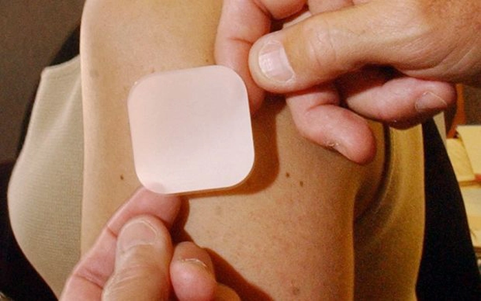 cineva pune un plasture pe umarul unei persoane