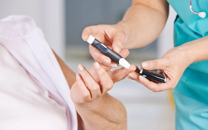doctor care verifica unui pacient nivelul de glicemie din sange