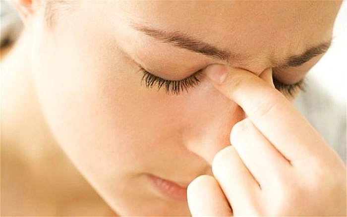 persoana care pune presiune cu degete pe sinusuri
