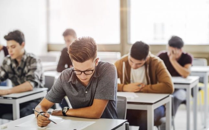  elevi care scriu in timpul unui examen 