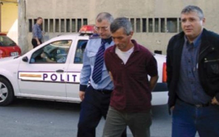 Un barbat in catuse, condus de un agent de Politie