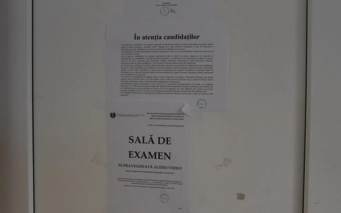 Afis pe care scrie “Sala de examen”, lipit pe usa