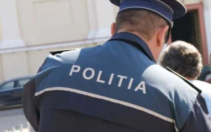  un politist care sta cu spatele