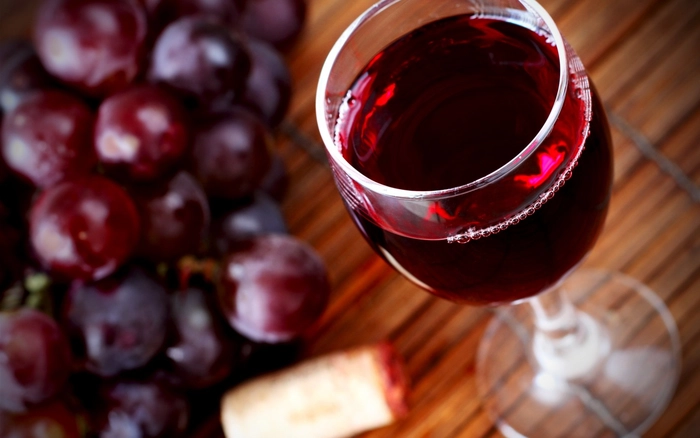 un pahar de vin langa smochine pe o masa