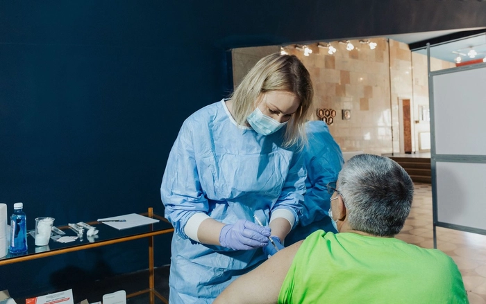 un medic care administreaza un vaccin împotriva Covid-19
