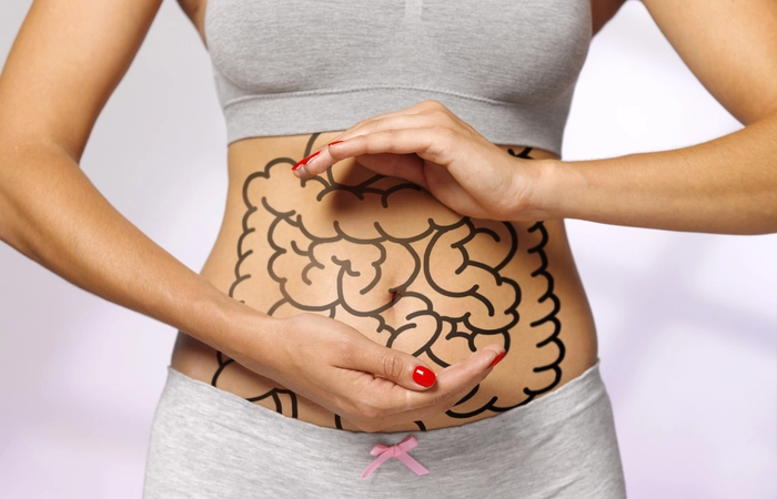 femeie care tine mainele in dreptul abdomenului si are desenat pe burta intestine