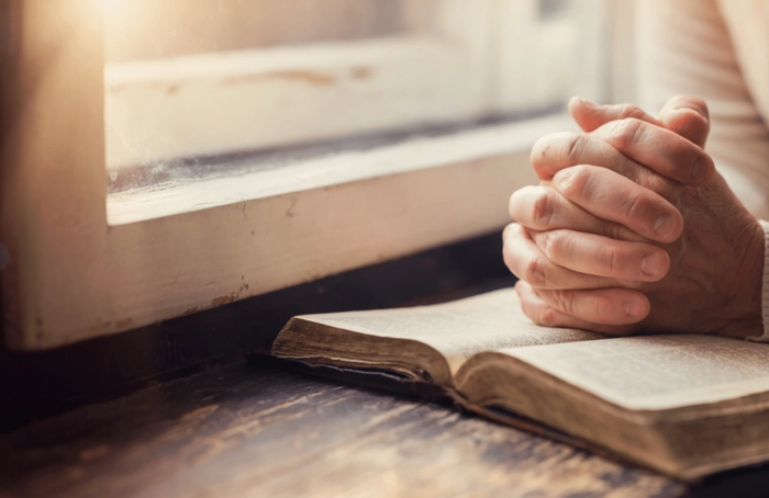 persoana care roaga cu biblia deschisa