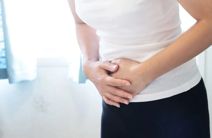 o femeie cu dureri în zona abdominala