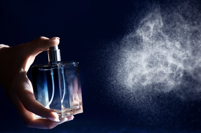 persoana care apasa pe un parfum