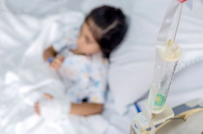 copil care sta langa aparatul de chimioterapie si urmeaza tratamentul