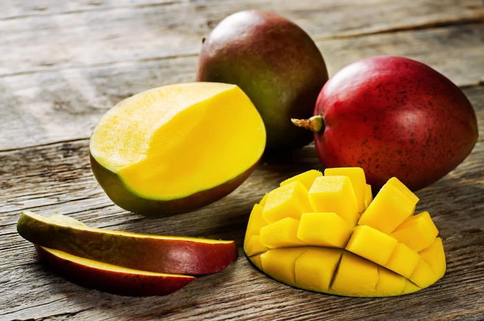 mango taiat si mango intreg pe o masa