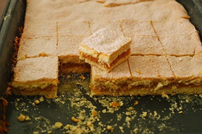o prajitura cu mere taiata in mai multe bucati