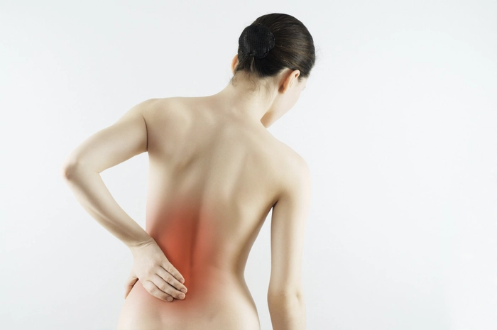 femeie care se tine de spate din cauza unui nerv sciatic blocat