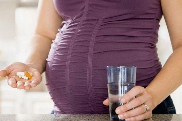 femeie încsărcinată care ia medicamente