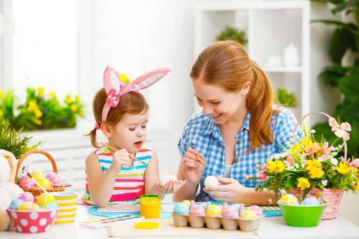 mama si copilul care picteaza pe oua de pasti