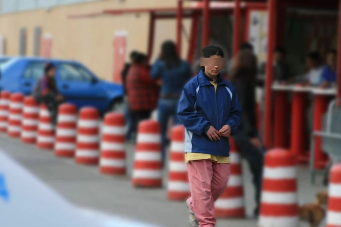 O femeie cu fata blurata se afla in fata unui supermarket