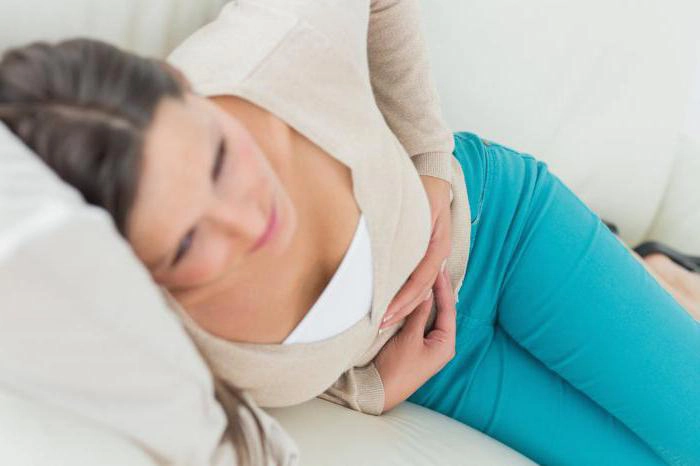 femeie care se tine de burta din cauza crampelor de implantare