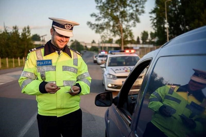 politest langa o masina neagra, mai multe autospeciale in fundal