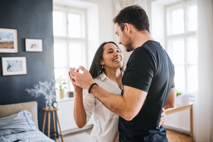 un cuplu care danseaza in apartament