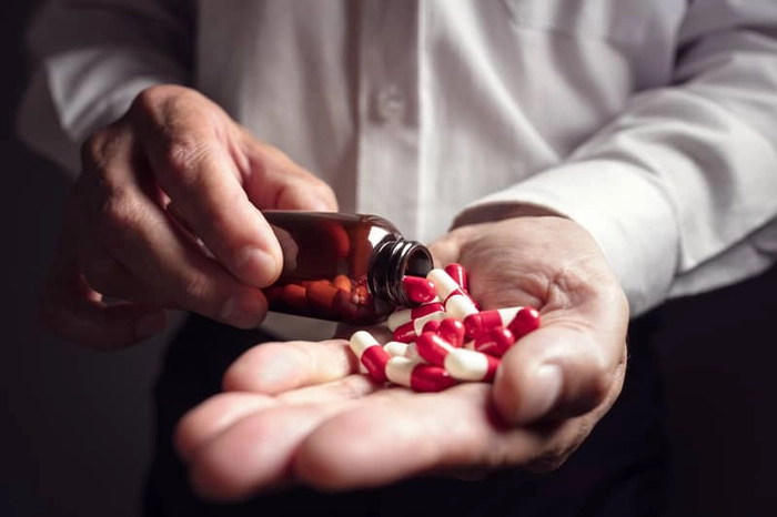 barbat care isi pune capsule in palma