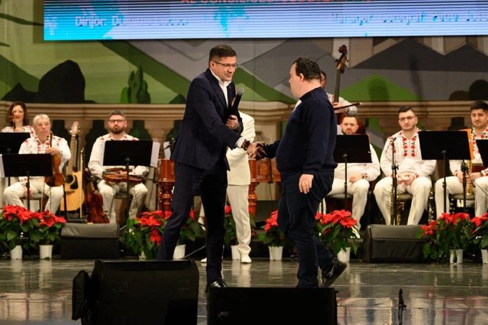 Costel Alexe dand mana cu o persoana medaliata