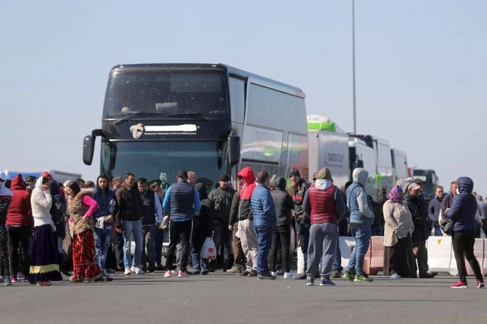 persoane in fata unui autocar 