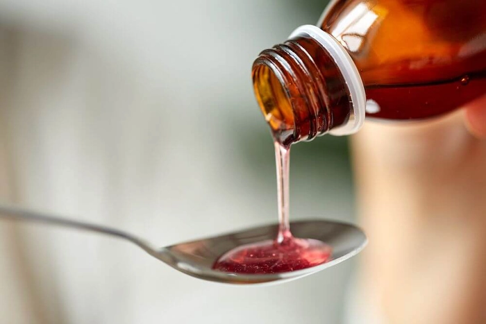 sirop ce curge dintr-un recipient pe o lingura