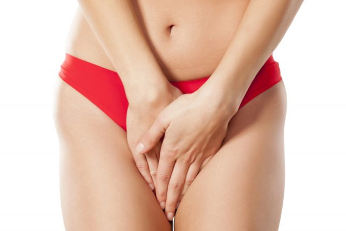 femeie in lenjerie intima care tine mainele in zona intima