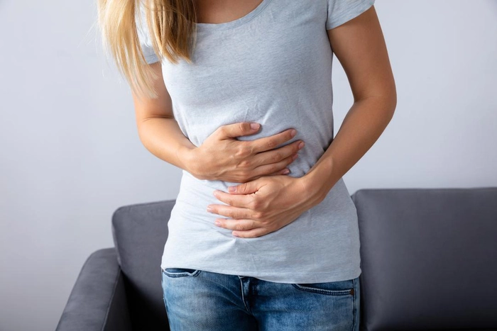 femeie care se tine de burta din cauza durerilor abdominale