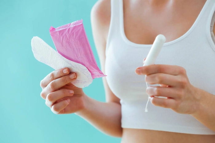 femeie care tine mai multe tipuri de absorbante