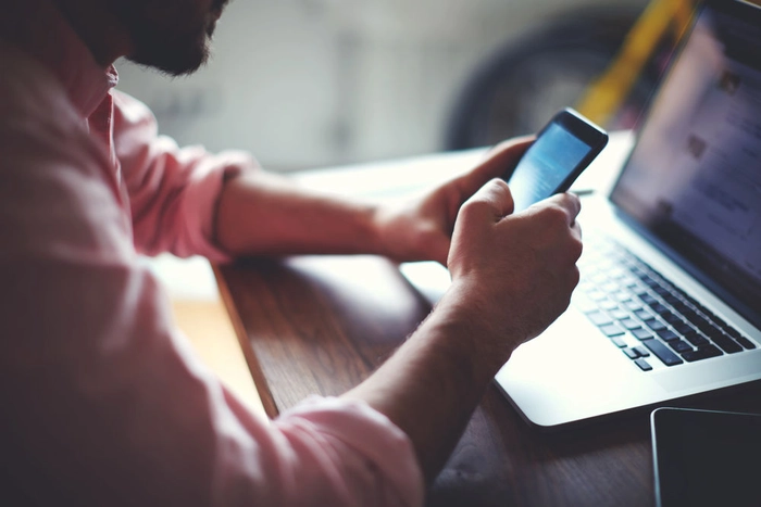 un baiat care scrie un mesaj pe telefon