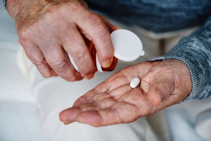 persoana care toarna dintr-un recipient un antibiotic in palma