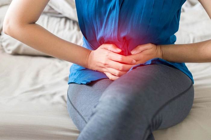 persoana care se tine cu mana de burta, acuza dureri la nivel abdominal