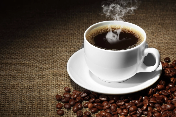 cana de cafea langa boabe de cafea