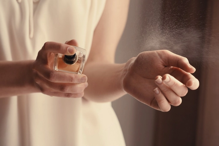 femeie care se parfumeaza la incheietura mainii