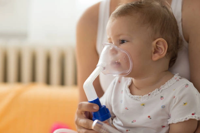 un bebeluș care face aerosoli