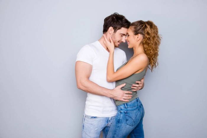 un barbat si o femeie care se imbratiseaza si se privesc in oci