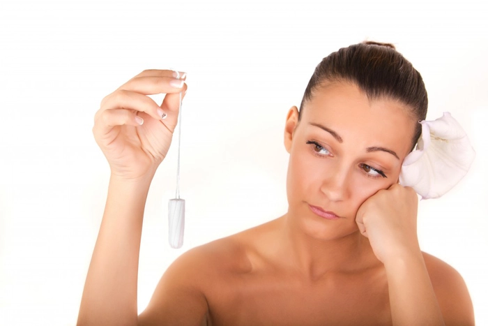 o femeie care privește un tampon pe care îl ține în mână