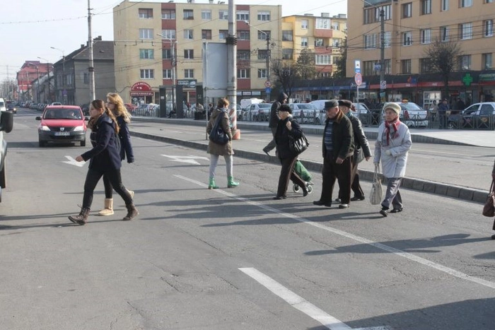 Mai multe persoane ce traverseaza strada neregulamentar