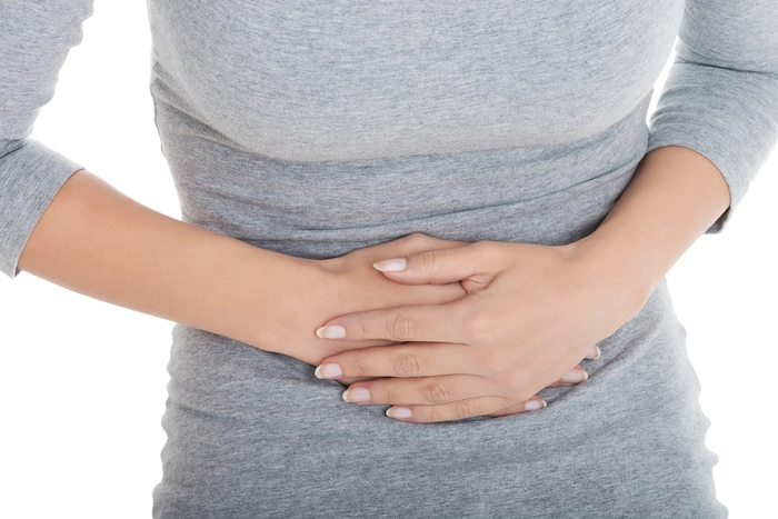 persoana care se tine de stomac din cauza sistemului digestiv
