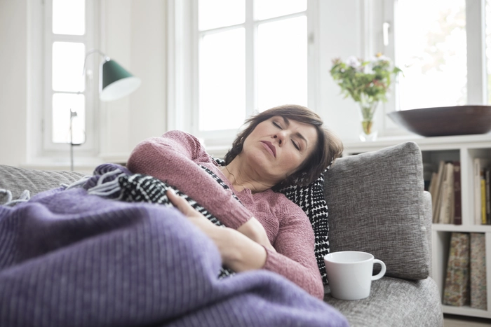 femeie care se tine de burta din cauza sangerarilor intre menstruatii