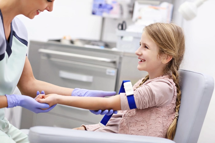 medic care ia o proba de sange din vena unui copil
