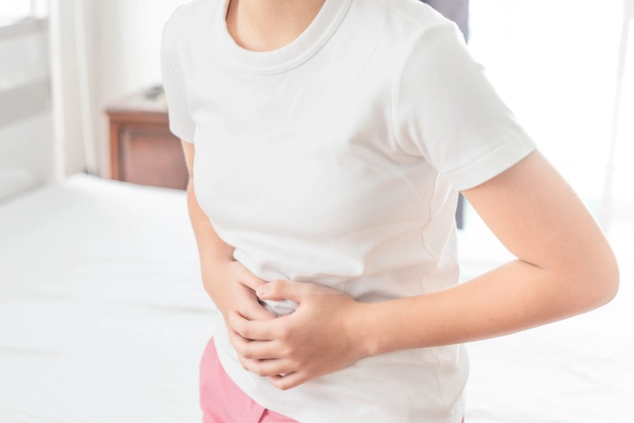 femeie care se tine de abdomen din cauza durerii provocate de pancreas