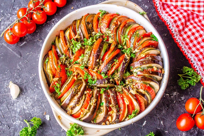 ratatouille intr-o tigaie langa mai multe ingrediente pe o masa