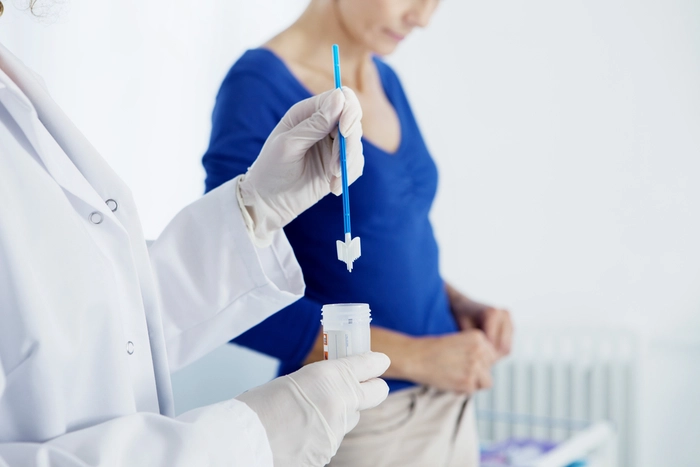 medic care colecteaza o proba de frotiu de la o femeie