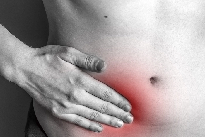 grafica barbat care se tine de partea dreapta a abdomenului din cauza durerii