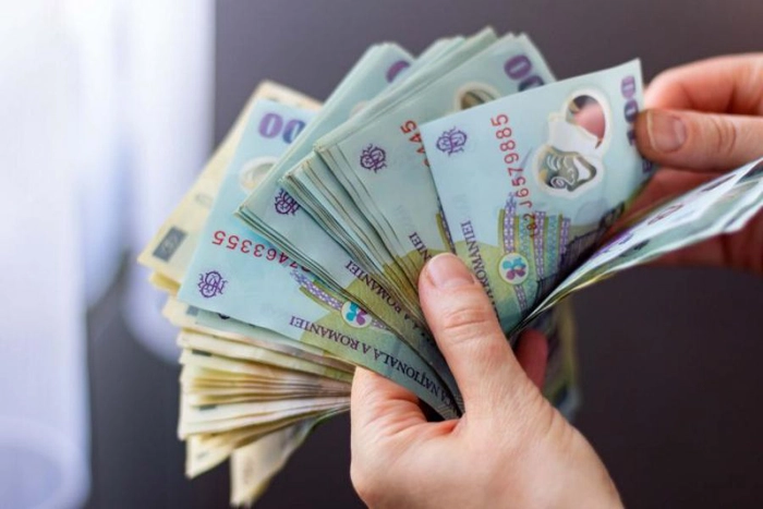 o persoana care tine mai multe bancnote in mana