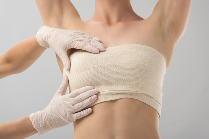 medic care tine mainele pe sanul unei femei pentru a o verifica