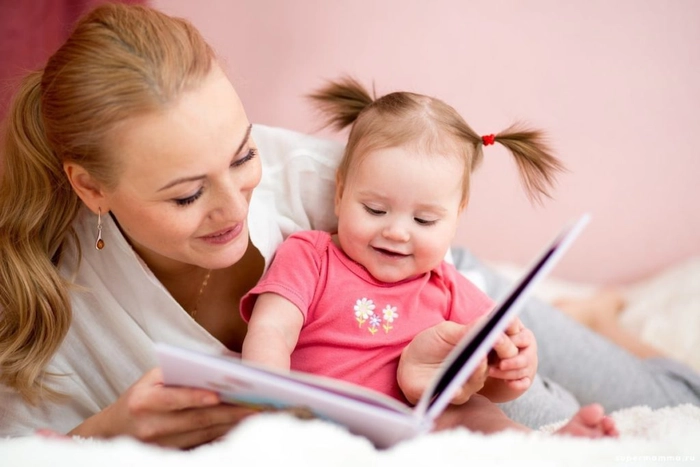 femeie care tine in mana o carte si ii citeste unei fetite